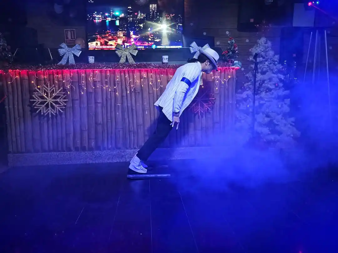 Michael Jackson tribute performer at Tropical Bar Benidorm executing the iconic anti-gravity lean amid stage lighting and fog effects.